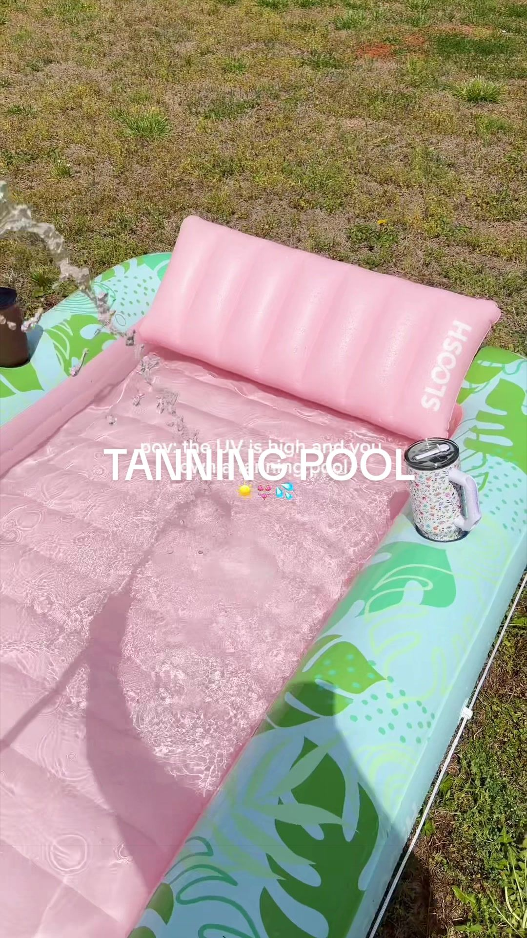 Inflatable tanning lounge being filled with water from a hose